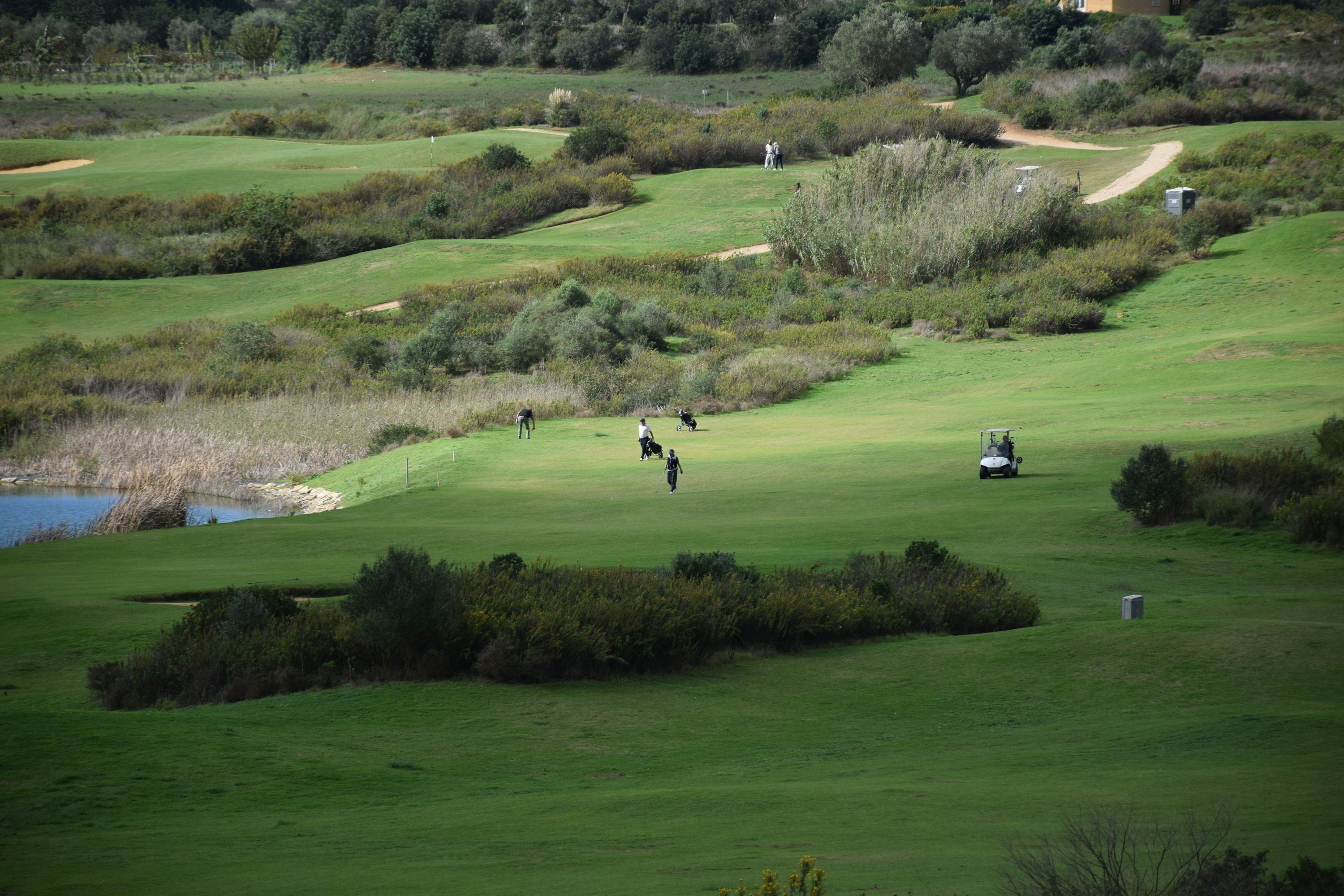 Vue aérienne d’un parcours de golf en Algarve montrant un fairway et un green entourés de végétation côtière