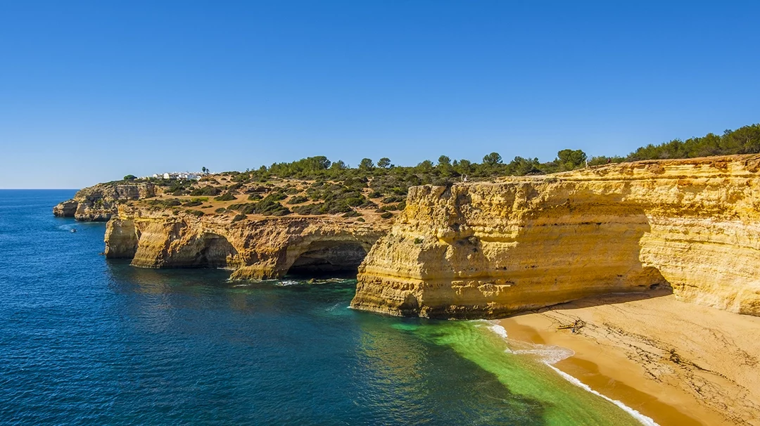 falaise côtière dorée surplombant une mer bleue azur, plage de sable; paysage de l’Algarve Portugal pour une location Algarve Portugal
